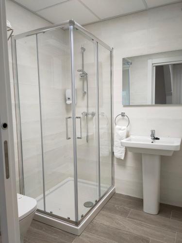 a bathroom with a glass shower and a sink at Las Huertas in La Penilla