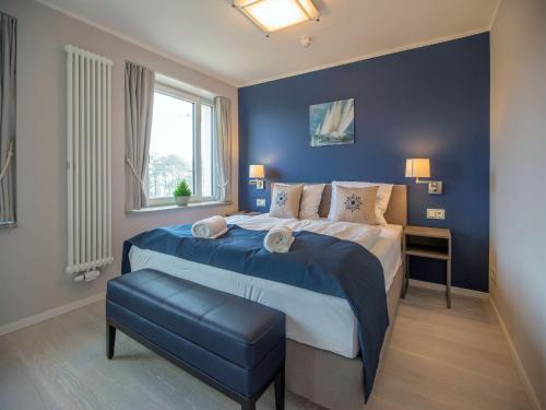 um quarto com uma cama grande e uma parede azul em Dünenresidenz Prora - Ferienwohnung mit Meerblick, 1 Schlafzimmer und Balkon NP-310 em Binz