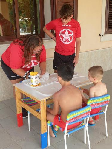 a woman and two children sitting in a bath tub at Kikki Village in Modica