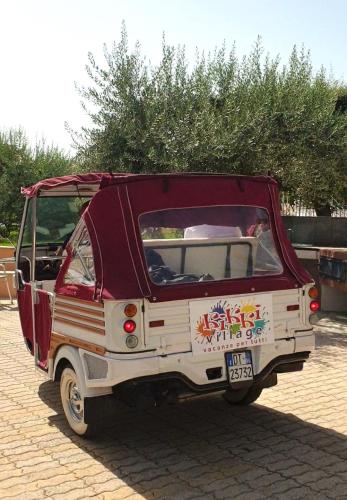 a small red and white car parked on a brick road at Kikki Village in Modica