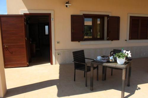 a table and chairs on a patio with a table and a door at Kikki Village in Modica