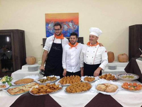 three chefs standing in front of a table of food at Kikki Village in Modica