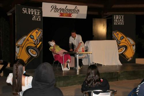 a man sitting at a table in front of a stage at Kikki Village in Modica