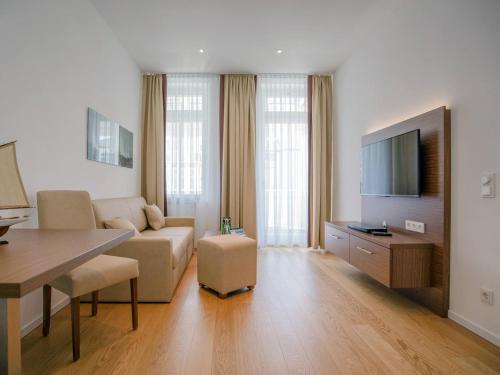 ein Wohnzimmer mit einem Sofa und einem Flachbild-TV in der Unterkunft Strandvillen Binz - Appartement mit 1 Schlafzimmer und Balkon SV-004 in Binz