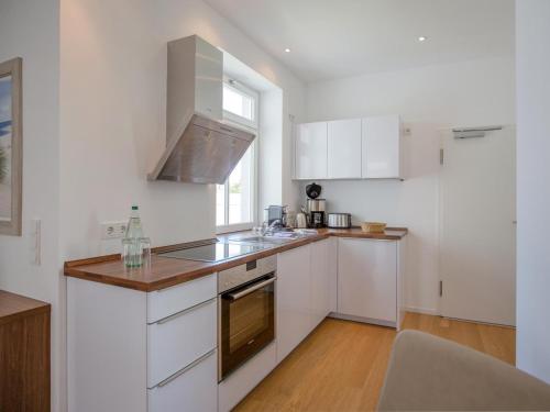 eine Küche mit weißen Schränken und einer Arbeitsplatte in der Unterkunft Strandvillen Binz - Appartement mit 1 Schlafzimmer und Balkon SV-004 in Binz