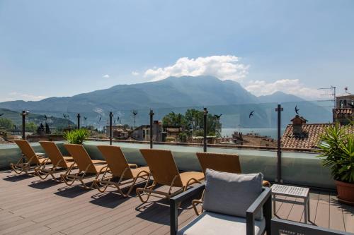 リーヴァ・デル・ガルダにあるHotel Antico Borgoの山のあるバルコニーに座る椅子