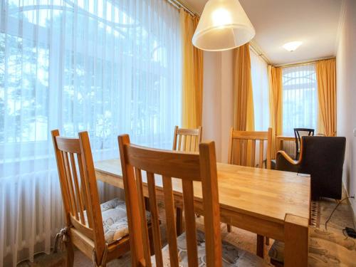 ein Esszimmer mit einem Tisch, Stühlen und einem Fenster in der Unterkunft Strandvillen Binz - Ferienwohnung mit Meerblick und 2 Schlafzimmern SV-556 in Binz