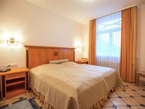 ein Schlafzimmer mit einem Bett und einem großen Fenster in der Unterkunft Strandvillen Binz - Ferienwohnung mit Meerblick und 2 Schlafzimmern SV-556 in Binz