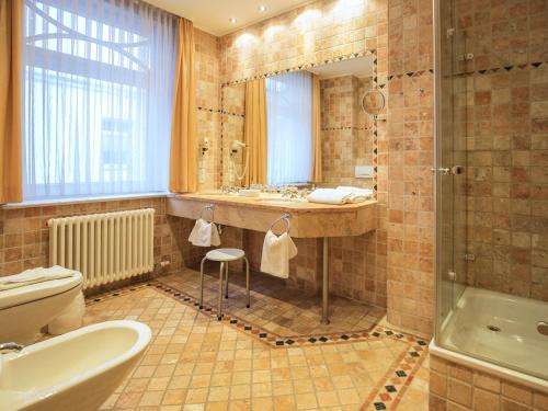ein Badezimmer mit einem Waschbecken, einem WC und einer Badewanne in der Unterkunft Strandvillen Binz - Ferienwohnung mit Meerblick und 2 Schlafzimmern SV-556 in Binz
