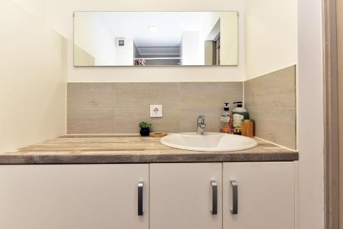een badkamer met een wastafel en een spiegel bij Apartment Ventspils in Ventspils
