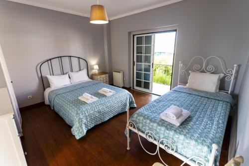 里巴馬爾的住宿－Villa Janota by AcasaDasCasas，一间卧室设有两张床和窗户。
