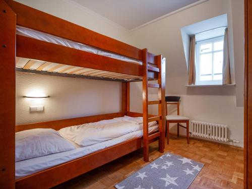um quarto com 2 beliches e uma cadeira em Strandvillen Binz - Ferienwohnung mit Meerblick, 2 Schlafzimmern und Balkon SV-713 em Binz