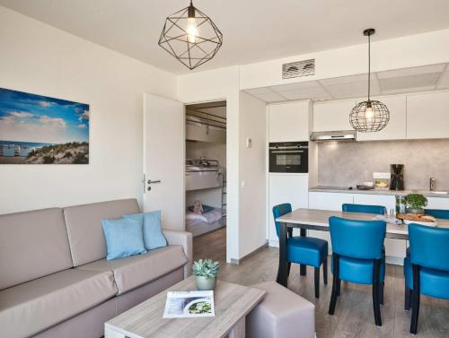 a living room and kitchen with a couch and a table at Holiday Suites Nieuwpoort in Nieuwpoort