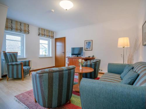 ein Wohnzimmer mit einem Sofa, Stühlen und einem Tisch in der Unterkunft Strandvillen Binz - Ferienwohnung mit Meerblick, 2 Schlafzimmern und Balkon SV-715 in Binz