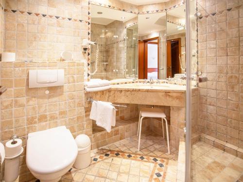 ein Badezimmer mit einem WC, einem Waschbecken und einem Spiegel in der Unterkunft Strandvillen Binz - Ferienwohnung mit Meerblick, 2 Schlafzimmern und Balkon SV-761 in Binz