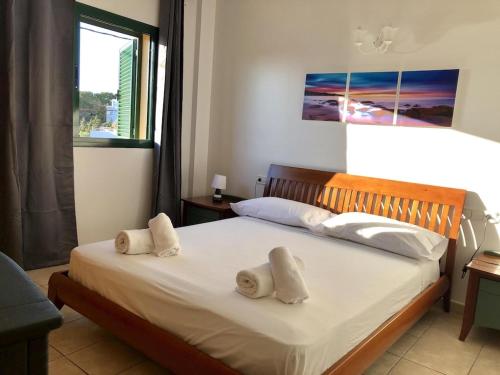 1 dormitorio con 1 cama con 2 toallas en La Mundial Formentera, en Es Pujols