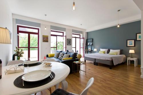 ein Wohnzimmer mit einem Bett, einer Couch und einem Tisch in der Unterkunft Porto Terrace Apartment in Porto