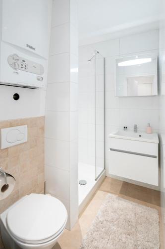 a white bathroom with a toilet and a sink at Theaterstudio 1 Antwerp in Antwerp
