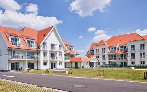 a row of houses with orange roofs on a street at Holiday Suites Nieuwpoort in Nieuwpoort