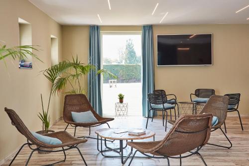 a waiting room with chairs and a flat screen tv at Holiday Suites Nieuwpoort in Nieuwpoort