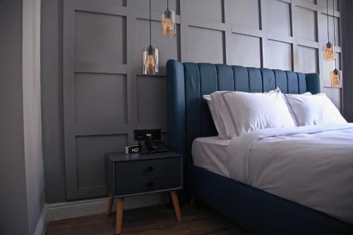 a bed with a blue headboard next to a night stand at HOTEL BRONTE in Istanbul