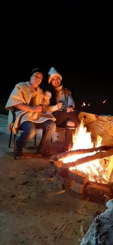 a group of people sitting around a fire at Cabañas Villas Del Lago in Cuítiva
