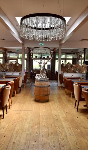 a restaurant with a large chandelier and tables and chairs at Gosau Apartment 209 in Gosau
