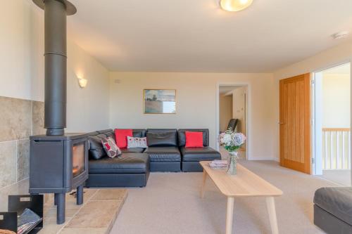 a living room with a couch and a wood stove at Hill View Rise in Chipping Campden