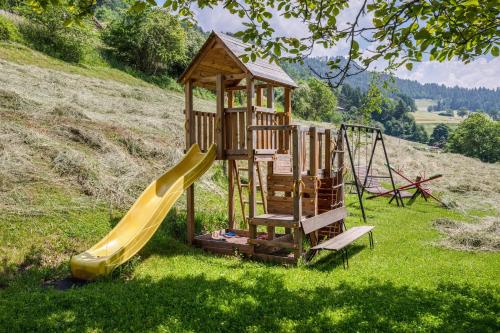 a wooden playground with a slide and a slideintend at Appartements Gabrielli Marie in Trodena