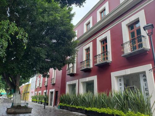 a row of pink buildings on a street at L Hotel Perla Boutique in Puebla