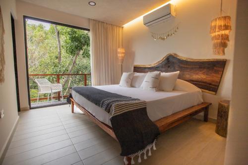 1 dormitorio con 1 cama grande y balcón en Luxury Condos Macondo Tulum, en Tulum