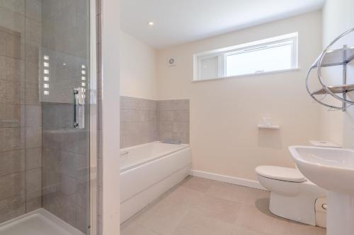 a bathroom with a tub and a toilet and a sink at Hill View Rise in Chipping Campden