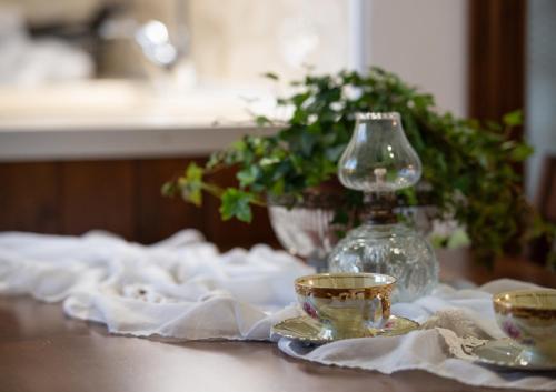 a table with a glass vase and two tea cups at Bosporus Apartments in Sarti