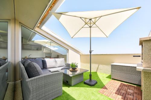 an outdoor patio with a table and an umbrella at Sea & River Vagueira Apartment by Home Sweet Home Aveiro in Praia da Vagueira