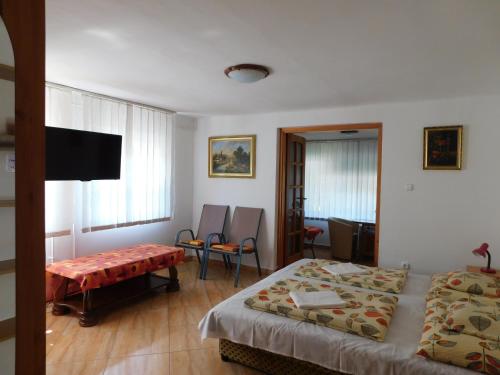 a bedroom with two beds and a flat screen tv at Szamóca Vendégház in Miskolctapolca