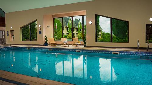 a large swimming pool with chairs and windows at Oranmore Lodge Hotel Conference And Leisure Centre Galway in Oranmore