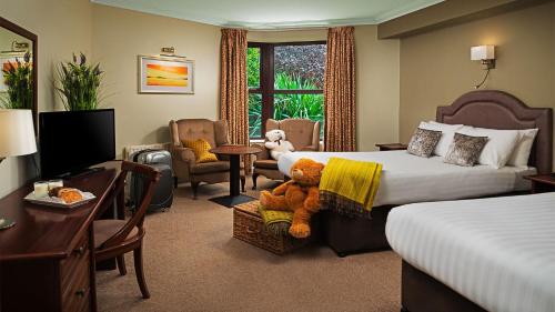 una habitación de hotel con una cama con un osito de peluche. en Oranmore Lodge Hotel Conference And Leisure Centre Galway, en Oranmore