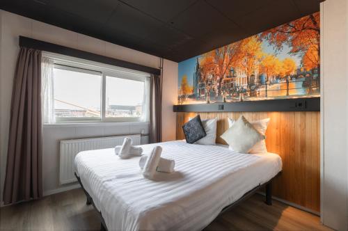 アムステルダムにあるボーテルのベッドルーム1室(壁に絵画が描かれた白い大型ベッド1台付)