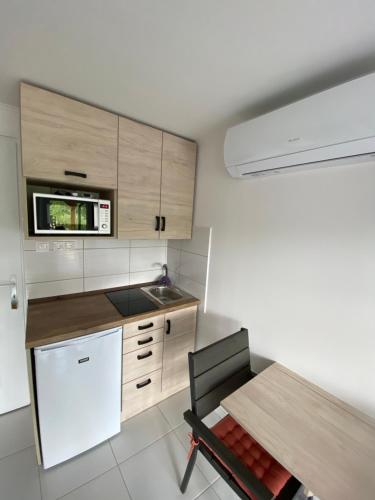 a kitchen with a wooden table and a white refrigerator at ZitaLaka in Igal