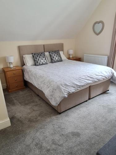a bedroom with a large bed and two night stands at Highfield Guest House in Sheringham