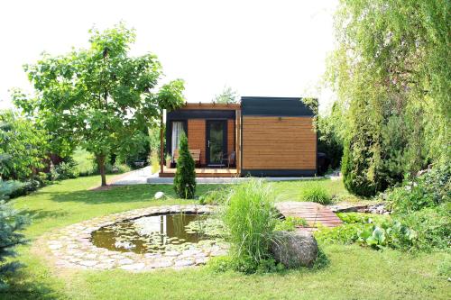una pequeña casa con un estanque en el patio en Domek Nad Zalewem, en Gołdap
