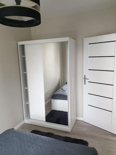 sypialnia z lustrem w rogu pokoju w obiekcie Apartament Słoneczny Taras w Kołobrzegu