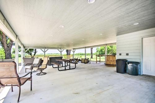an empty porch with chairs and tables and windows at 2 Mi to Marinas and Grove Cozy Cabin with Grill in Grove