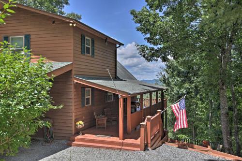 a house with a porch and an american flag at Picturesque Murphy Cabin with Fire Pit and Views! in Murphy