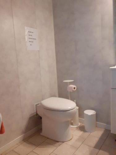 a bathroom with a toilet and a paper on the wall at Maison d'Hôtes La Douloire in Pernes-les-Fontaines