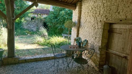 a patio with a table and chairs in a yard at Fig Tree Barn in Gibourne