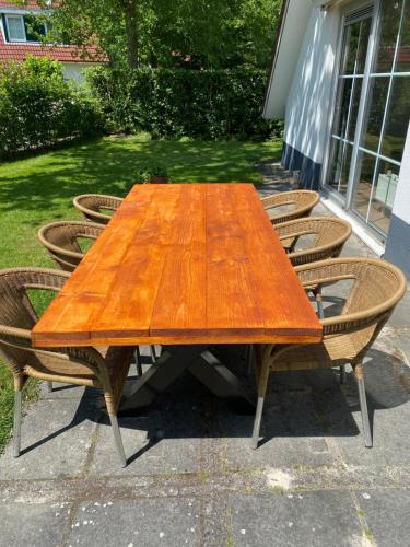 a wooden table with chairs around it in a yard at Vakantiewoning 'Eysinga State' in Sint Nicolaasga