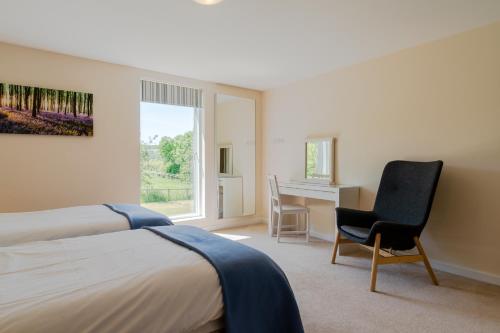 a bedroom with a bed and a desk and a chair at Hill View Rise in Chipping Campden