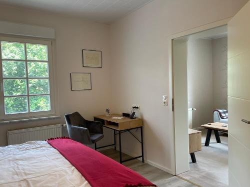a bedroom with a bed and a desk and a window at Ferienwohnung Annika in Hückeswagen