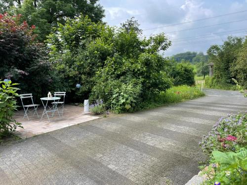 a road with a table and chairs next to a bush at Ferienwohnung Annika in Hückeswagen